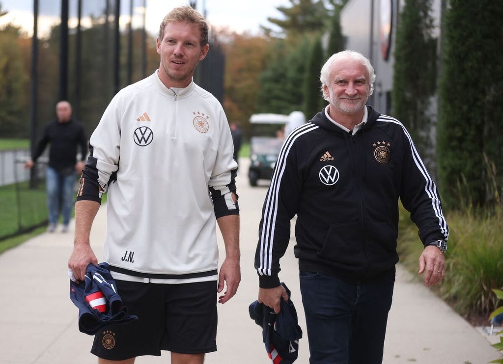 Pelatih timnas Jerman, Julian Nagelsmann (kiri), dan Direktur Olahraga Federasi Sepak Bola Jerman Rudi Voller berjalan bersama menuju lokasi latihan timnas Jerman sebelum menghadapi timnas AS di Foxborough, Massachusetts, AS, Kamis (12/10/2023).