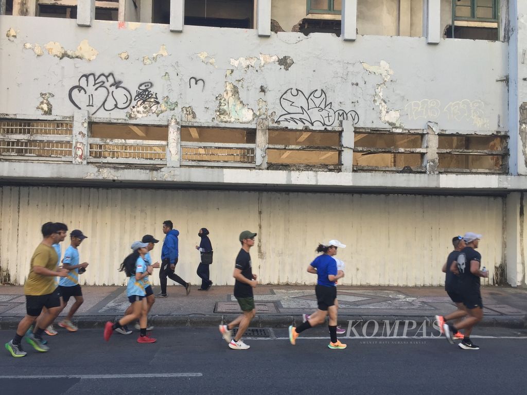 Pelari dari 10 komunitas lari melintasi bangunan tua di Jalan Tunjungan saat mengikuti The Tour Surabaya, Jawa Timur, Sabtu (22/7/2023). 