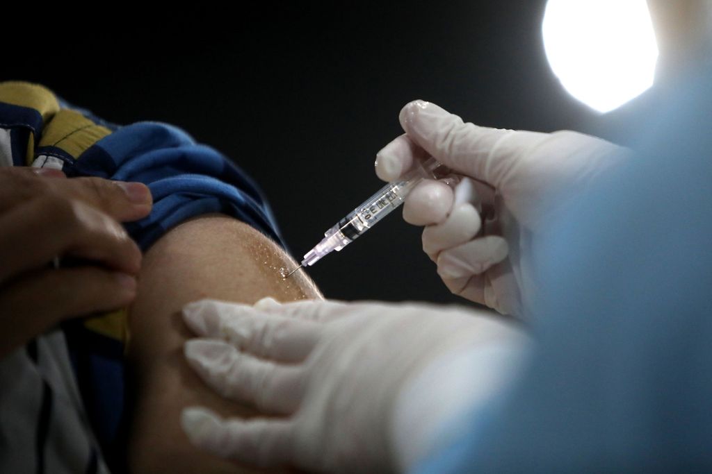 Tenaga medis menyuntikkan vaksin Covid-19 dosis ketiga atau ” kepada pekerja di Menara Kompas, Jakarta, Selasa (25/1/2022). Vaksin penguat produksi Pfizer ini diberikan kepada mereka yang vaksinasi pertama dan kedua mendapatkan vaksin Sinovac. Vaksin ”booster” dinilai ampuh dalam menangkal Covid-19 varian Omicron.
