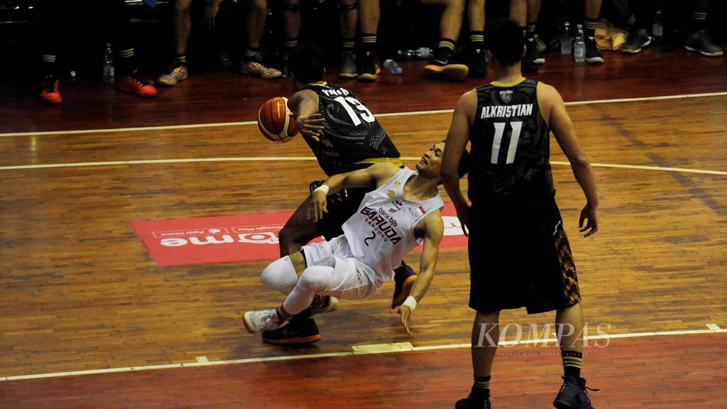 Januar (tengah) pemain Bank BJB Garuda Bandung berusaha menembus pertahanan dari Bima Perkasa Jogja dalam laga Liga Basket Indonesia di GOR Sahabat, Kota Semarang, Jawa Tengah, Kamis (8/12).