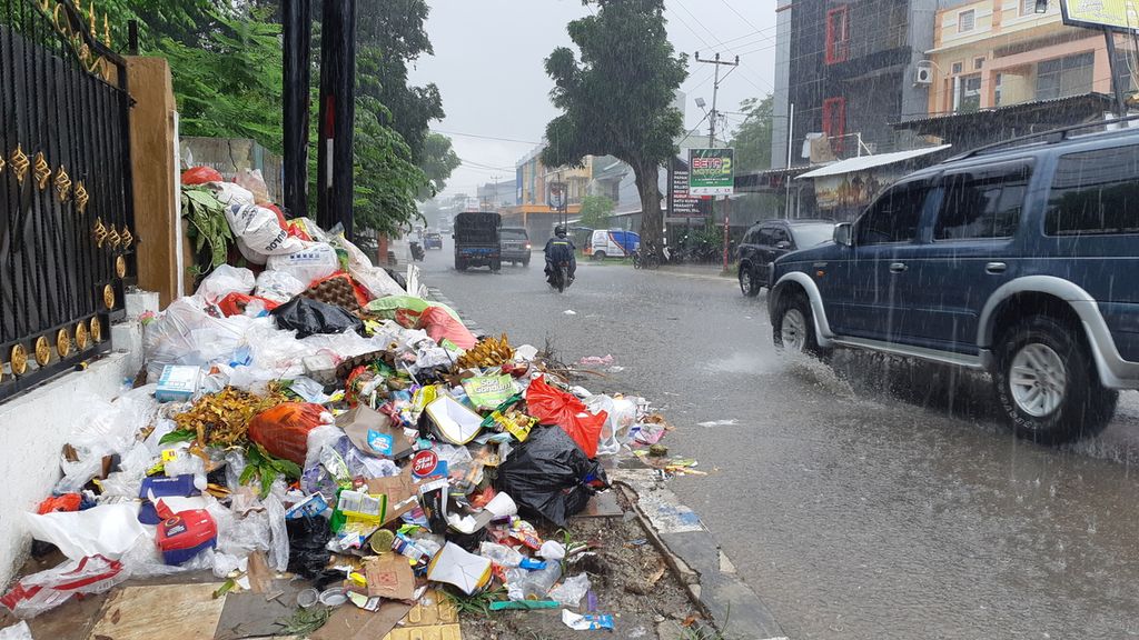 Sampah di tempat pembuangan sampah sementara masuk hingga ke badan Jalan Tompelo, Kota Kupang, Nusa Tenggara Timur, Minggu (12/12/2021). Selama lebih dari satu hari, sampah di pusat kota itu tidak ditangani.