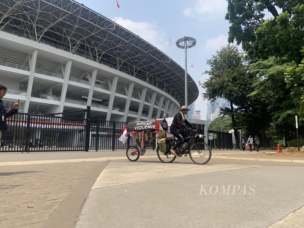 Miftahuddin Ramli (52) terpaksa kembali dari Stadion Utama Gelora Bung Karno usai niatnya membawa masuk sepeda yang membawa pesan Tragedi Kanjuruhan ditolak petugas keamanan, Senin (14/8/2023) siang, di Jakarta. Pria yang akrab disapa Midun itu memulai perjalanan menaiki sepeda dari Malang dan tiba di  Stadion Utama Gelora Bung Karno setelah 12 hari.