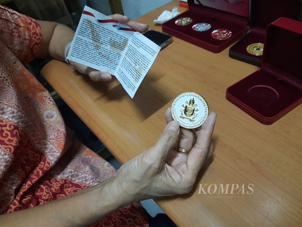 Pemilik Onie Craft, Yosephine E Onie, menunjukkan koin Paus Fransiskus sebagai suvenir lawatan pemimpin umat Katolik dunia itu di bilangan Petogogan, Jakarta, Kamis (29/8/2024). Koin itu berdiameter 45 mm x 3 mm. 