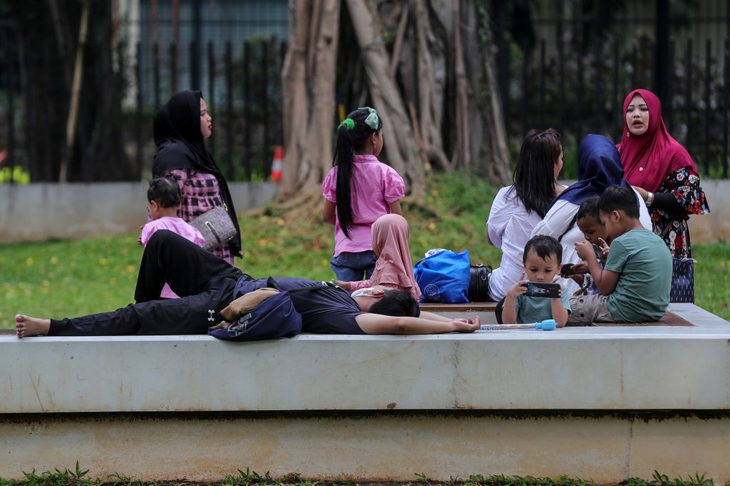 Beberapa anak tetap bermain gawai meski saat itu tengah berlibur bersama keluarganya di Taman Lapangan Banteng, Jakarta, (2/7/2023). Candu gawai, internet, media sosial, dan gim daring dapat menimbulkan gangguan konsentrasi pada anak.