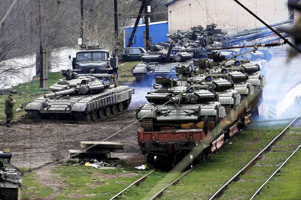 A Russian soldier (L) guides a Ukranian tank which will be loaded onto a train in northern Crimea March 27, 2014. 