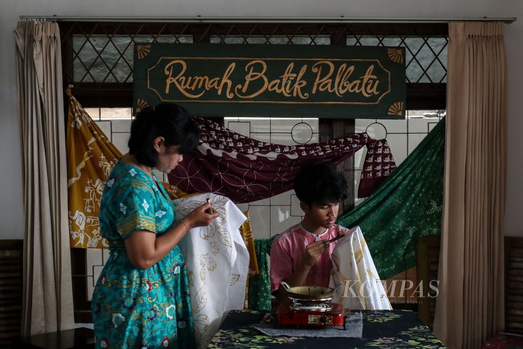 Dua perajin mencanting kain batik di Rumah Batik Palbatu, Tebet, Jakarta Selatan, Minggu (1/10/2023). Rumah Batik Palbatu masih melestarikan pembuatan batik dengan cara manual baik dengan canting atau cap.