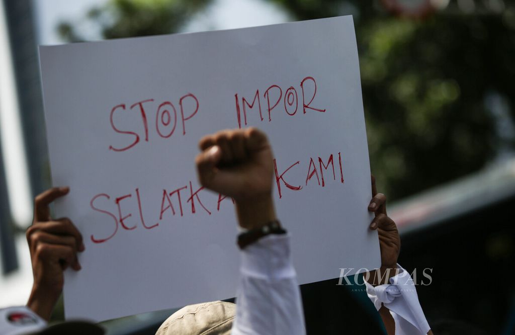 Poster bernada tolak impor dibawa oleh pengunjuk rasa yang tergabung dalam Aliansi Industri Kecil Menengah (IKM) dan Pekerja Tekstil Nasional berunjuk rasa dengan melakukan <i>long march</i> di Jalan Medan Merdeka Selatan menuju Patung Kuda Arjuna Wiwaha, Jakarta, Kamis (27/6/2024). 