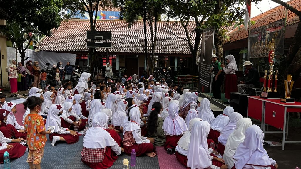 Sejumlah anak saat mendengarkan dongeng cerita rakyat di halaman SDN Pondok Cina 1, Depok, Jawa Barat, Selasa (20/12/2022).