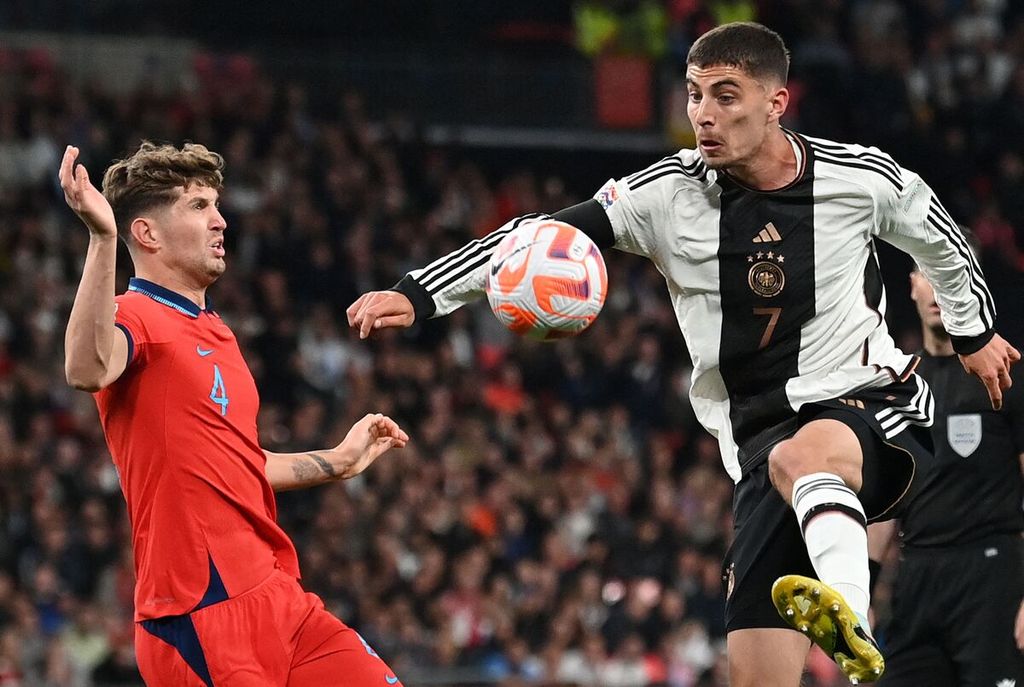 John Stones, bek timnas Inggris, berupaya menghadang gelandang Jerman, Kai Havertz, pada laga Liga Nasional Eropa di Stadion Wembley, London, Inggris, 26 September 2022. Laga itu berakhir imbang, 3-3.