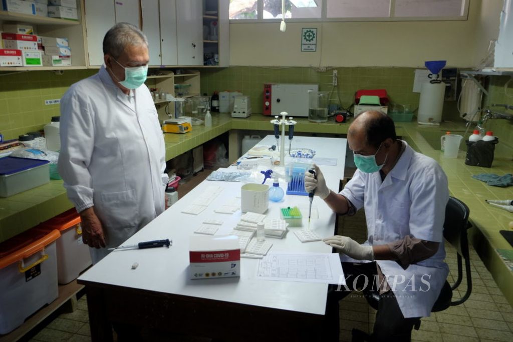 Direktur Laboratorium Hepatika Bumi Gora yang juga Guru Besar Fakultas Kedokteran Universitas Mataram sekaligus peneliti Mulyanto (kiri), mengawasi pembuatan prototipe alat tes diagnostik cepat (RTD) RI-GHA Covid-19 RDT IgG/IgM di Laboratorium Hepatika Bumi Gora di Mataram, Nusa Tenggara Barat, Senin (1/6/2020). RI-GHA (Republik Indonesia-Gadjah Mada-Hepatika Mataram-Airlangga), merupakan RDT buatan dalam negeri yang melibatkan peneliti dari Universitas Gadjah Mada, Laboratorium Hepatika Bumi Gora Mataram, dan Universitas Airlangga. Setelah proses validasi selesai, RI-GHA yang telah diluncurkan Presiden Joko Widodo dan mendapat izin edar akan diproduksi massal pada akhir Juni 2020.