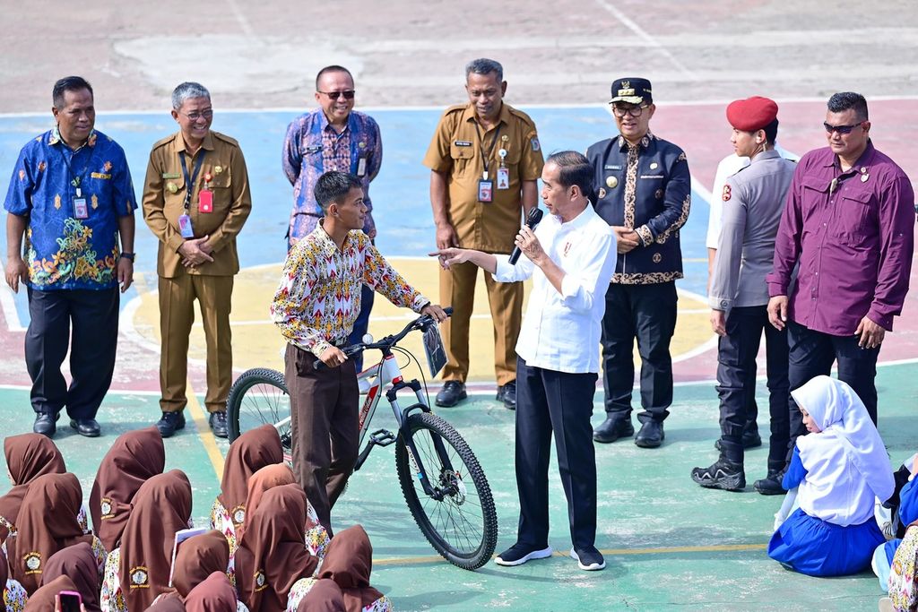 Presiden Joko Widodo memberikan kuis berhadiah sepeda di SMK Negeri 1 Tanah Grogot, Kabupaten Paser, Kalimantan Timur, Kamis (26/9/2024).