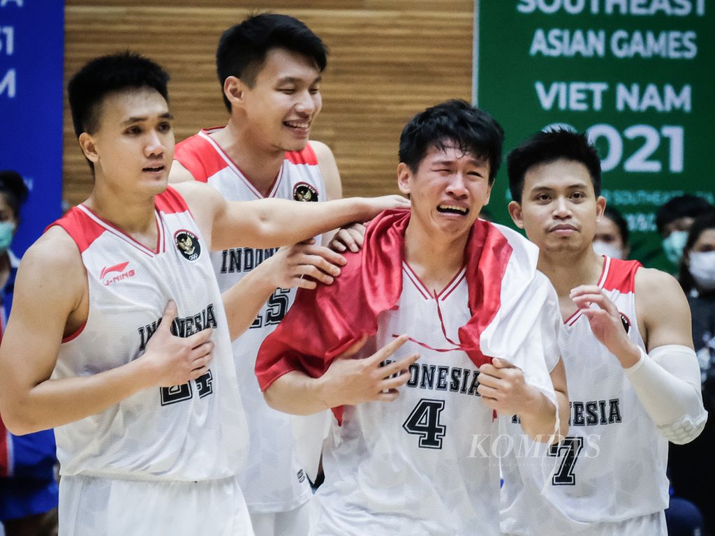 Para pemain timnas basket merayakan raihan emas SEA Games Vietnam 2021 di Thanh Tri Indoor Stadium, Hanoi, 22 Mei 2023. <i>Guard</i> timnas Abraham Damar Grahita (mengalungi bendera) sangat emosional. Dia tidak berhenti menangis kejer dari lapangan hingga ruang ganti.