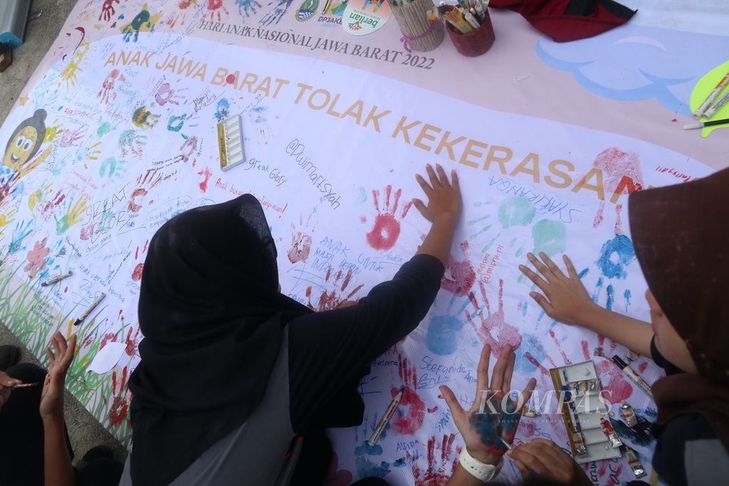 Sejumlah anak membubuhkan tanda tangan di spanduk kampanye stop kekerasan terhadap anak dalam Peringatan Hari Anak Nasional tingkat Jawa Barat di Kabupaten Kuningan, Kamis (28/7/2022). Mereka juga menuliskan harapan mereka agar anak-anak mendapatkan hak pendidikan hingga terbebas dari perundungan.