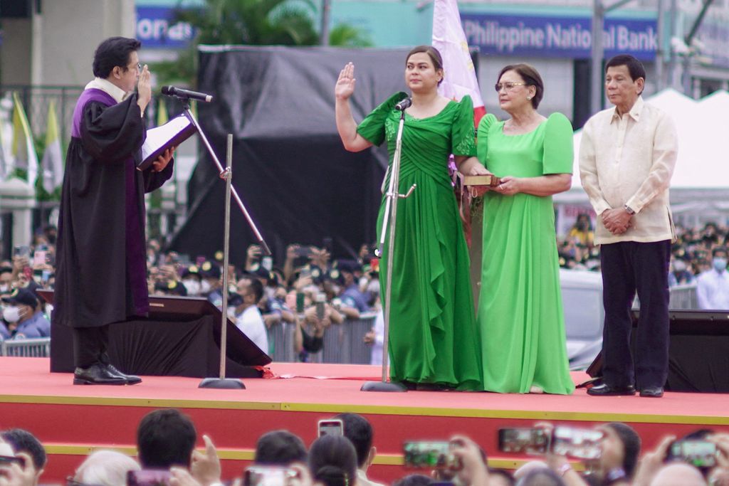 Wakil Presiden Filipina Sara Duterte-Carpio (kiri) diambil sumpah jabatannya didampingi ibunya, Elizabeth Zimmerman (kedua dari kanan) dan ayahnya, Presiden Rodrigo Duterte (kanan), dalam upacara di dekat Balai Kota Davao, 19 Juni 2022. 