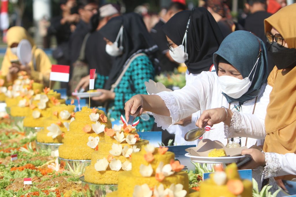 Sejumlah warga menikmati tumpeng yang disajikan seusai Upacara Peringatan Hari Jadi Ke-77 Jawa Barat di Lapangan Gasibu, Kota Bandung, Jabar, Jumat (19/8/2022).