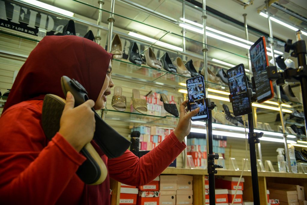 Pedagang berinteraksi dengan penonton di media sosial Tiktok saat menawarkan dagangannya secara langsung lewat daring di kios Blok A Tanah Abang, Jakarta Pusat, Selasa (13/6/2023). Penjualan secara daring menjadi salah satu strategi para pedagang untuk menjangkau konsumen yang lebih luas. 