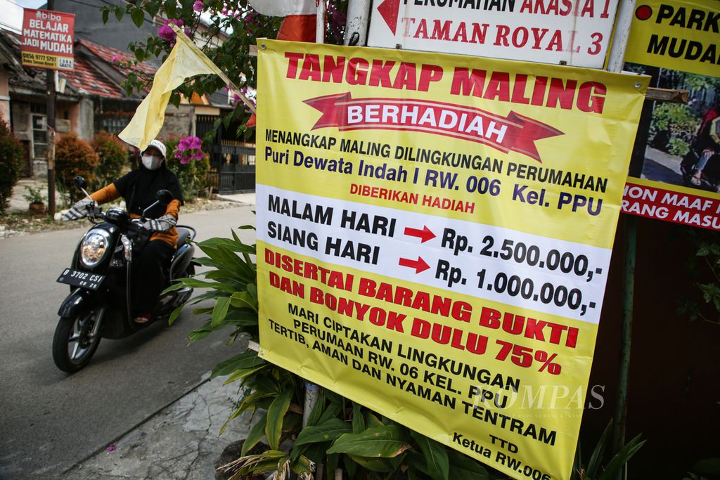 Spanduk bertuliskan ”tangkap maling berhadiah” terpampang di sejumlah sudut jalan Perumahan Puri Dewata Indah, Cipondoh, Kota Tangerang, Banten, Selasa (23/4/2023). 
