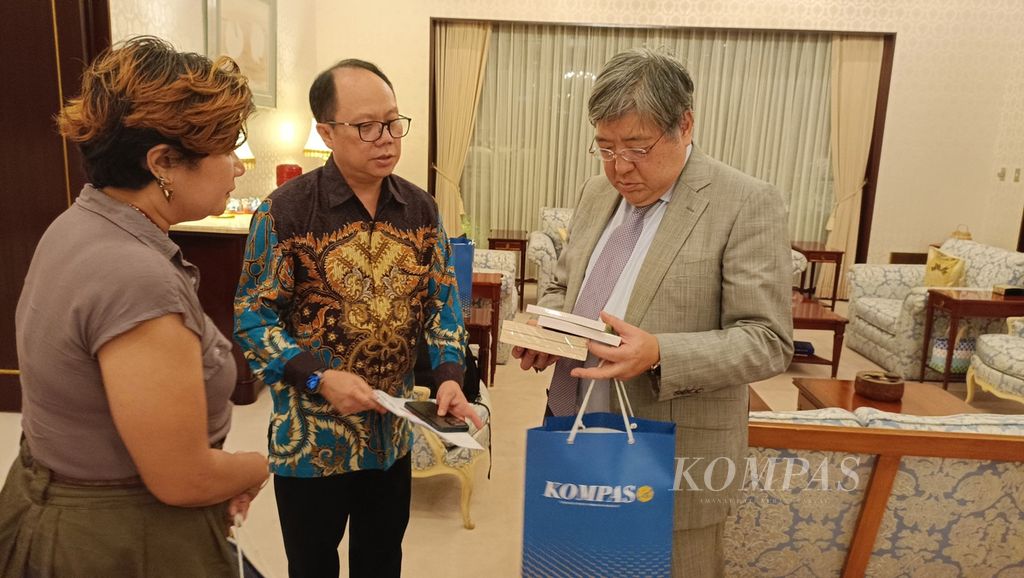 Duta Besar Jepang untuk Indonesia Masaki Yasushi (kanan) menerima buku sebagai cendera mata dari Pemimpin Redaksi <i>Kompas/</i>Kompas.id Sutta Dharmasaputra (tengah) dalam jamuan makan malam di kediaman Dubes Jepang di Jakarta, Senin (29/4/2024). 