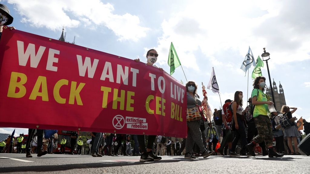 Para aktivis kelompok Extinction Rebellion membentangkan spanduk saat berpawai menuju Lapangan Parlemen di pusat kota London, Inggris, dalam aksi krisis iklim, Selasa (1/9/2020). 
