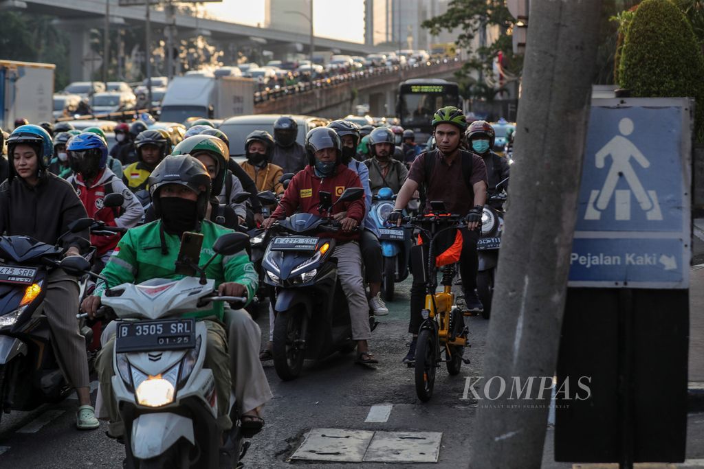 Pesepeda terjebak kemacetan di Jalan Gatot Subroto, Jakarta, Rabu (9/8/2023). Kemacetan dan polusi udara masih menjadi permasalahan yang tak kunjung selesai di Jakarta. Badan Pusat Statistik mencatat, jumlah kendaraan di Jakarta pada 2022 mencapai 26,3 juta unit. 