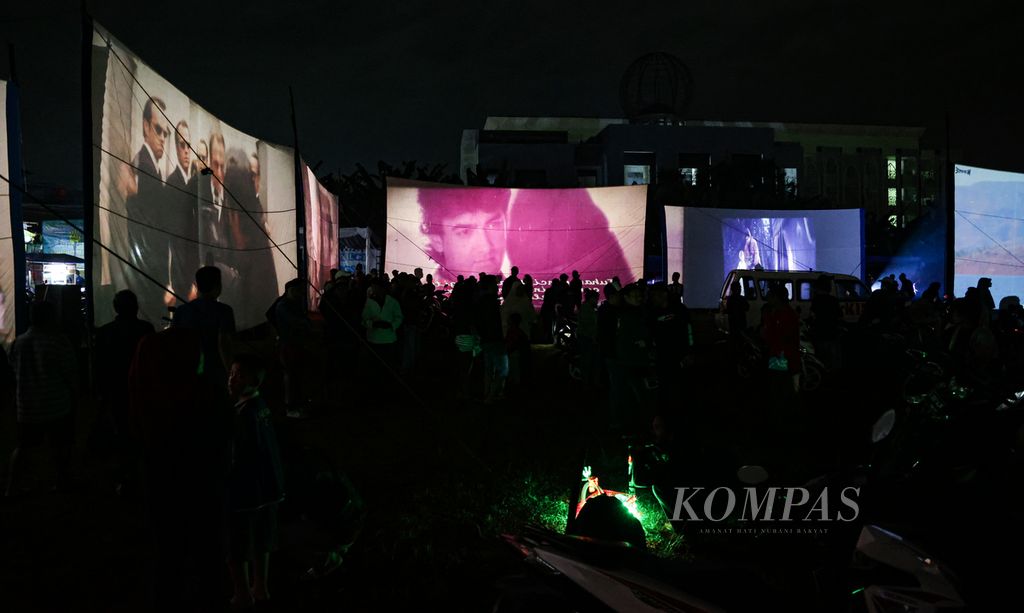 Warga memadati lapangan tempat berlangsungnya festival layar tancap di Babakan, Kecamatan Setu, Tangerang Selatan, Banten, Rabu (18/1/2023) malam. Kegiatan dalam rangka ulang tahun perkumpulan pencita layar tancap itu menjadi hiburan warga. 