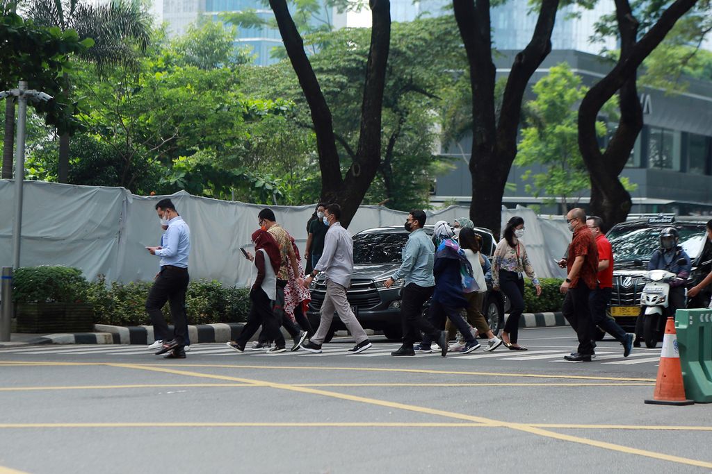Karyawan di kawasan Sudirman Central Business District (SCBD), Jakarta Selatan, melintasi zebra cross, Rabu (02/11/2022). 