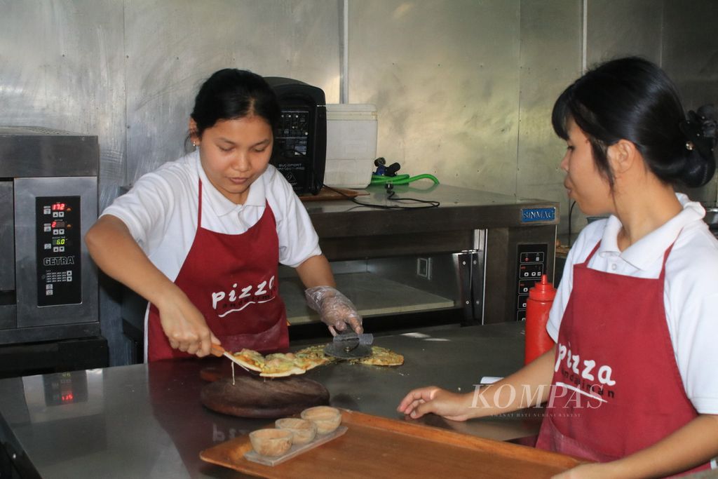 Juru masak menyiapkan pizza andaliman di Kecamatan Balige, Kabupaten Toba, Sumatera Utara, Selasa (19/12/2023). Sejak penerbangan langsung Jakarta-Silangit dibuka beberapa tahun lalu, kuliner lokal kini naik kelas menjadi makanan kafe dan restoran.