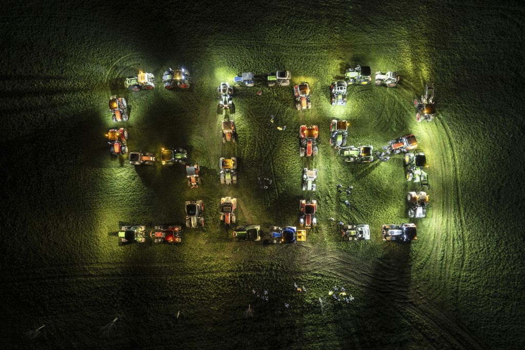Para petani menata traktor-traktor mereka membentuk huruf raksasa "SOS" (<i>save our soul</i>/selamatkan kami) dalam unjuk rasa di Gossau, Swiss, 29 Februari 2024. 