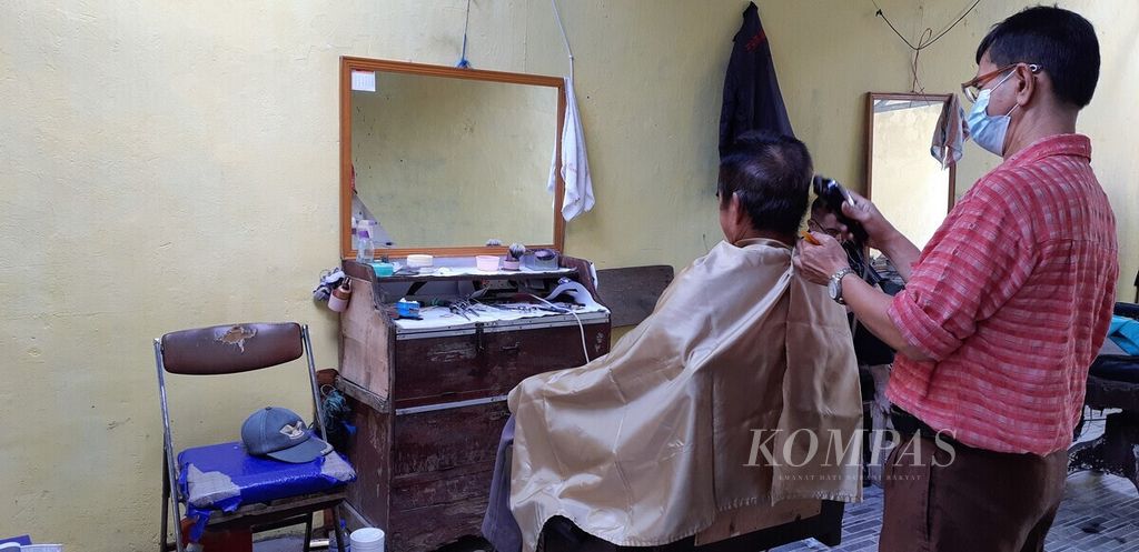 Usaha potong rambut bertahan di jalur pedagang kaki lima kawasan Pasar Jambi. Tukang cukur rambut mencoba bertahan dengan tetap menggunakan masker demi menekan penyebaran virus korona baru.