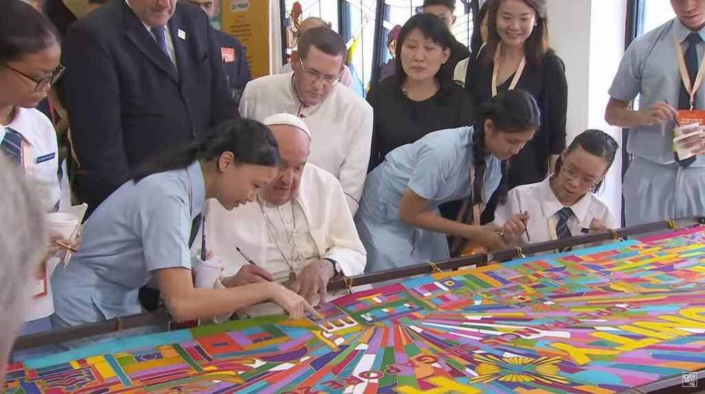 Paus Fransiskus membubuhkan tinta di lukisan karya anak muda Singapura seusai pertemuan dengan pemuda lintas agama di Singapura, Jumat (13/9/2024).