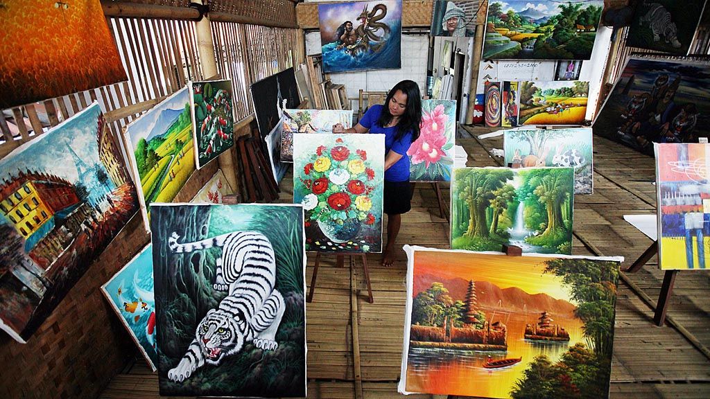 Dian menata sejumlah karya pelukis setempat di galerinya di Jelekong, Kabupaten Bandung, Jawa Barat, Jumat (17/2). 