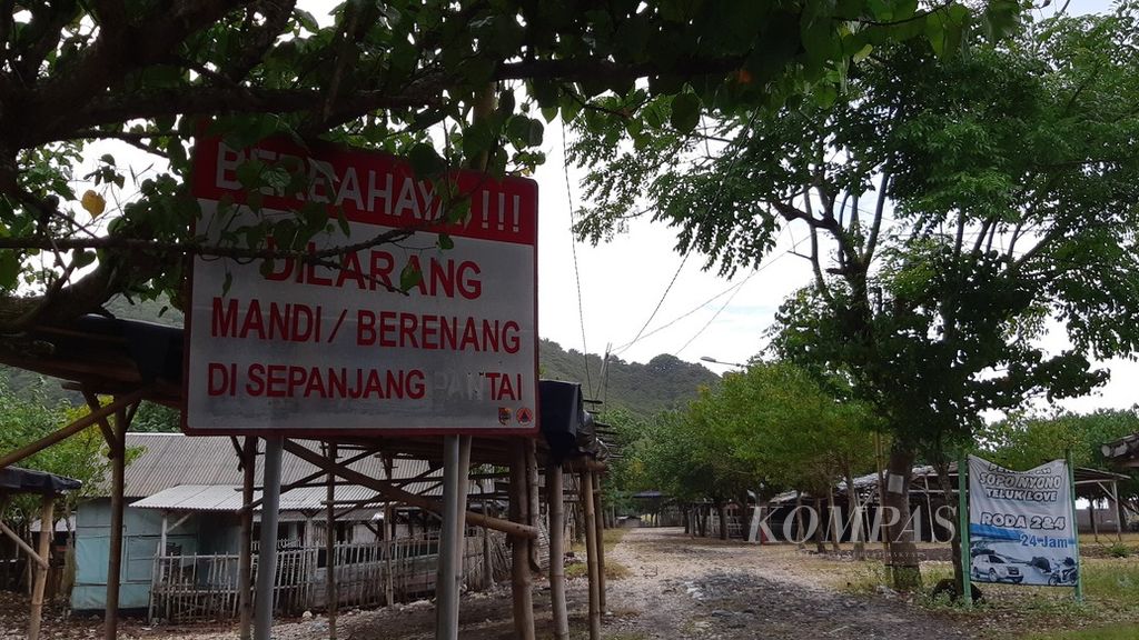 Sebuah papan berisi larangan berenang dan mandi di pantai terpampang di kawasan Pantai Payangan di Desa Suberejo, Kecamatan Ambulu, Kabupaten Jember, Jawa Timur, sebagaimana difoto pada Selasa (15/2/2022).