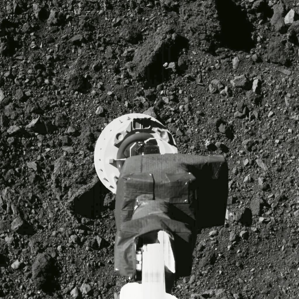 Dalam foto bertanggal 11 Agustus 2020 ini, tampak lengan wahana OSIRIS-REx sedang melakukan uji coba untuk mendekati situs sampel Nightingale di permukaan asteroid Bennu. 
