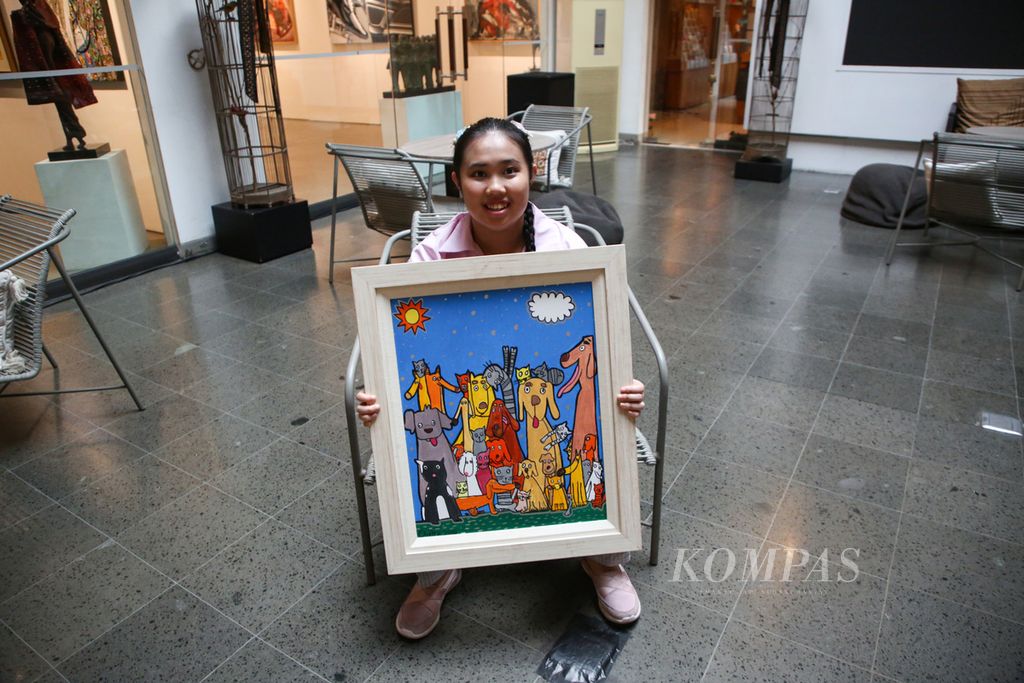 Claire Nicole Stephanie Siregar, orang dengan autis, memperlihatkan lukisannya yang berjudul "Togetherness" di Jakarta, Rabu (10/5/2023). Karya tersebut baru saja selesai diikutkan dalam pameran seni rupa bertajuk "Bianglala Seribu Imajinasi" di Bentara Budaya Jakarta.