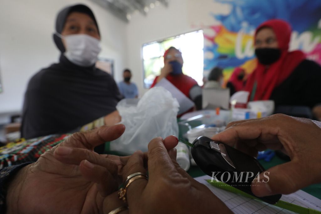 Kader posyandu memeriksa sampel darah lansia di Balai RT 012, RW 007, Kelurahan Pondok Kelapa, Jakarta Timur, Kamis (14/7/2022). Pelayanan jemput bola dari ke balai warga ini dilakukan kader posyandu selama pandemi Covid-19. 