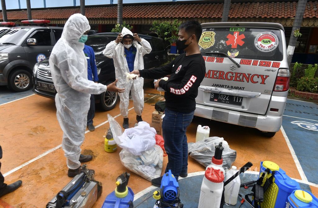 Sukarelawan bersiap mengenakan pakaian pelindung dan menyiapkan sejumlah peralatan sebelum melakukan penyemprotan disinfektan di SMPN 89 Jakarta Barat, Rabu (26/1/2022). 