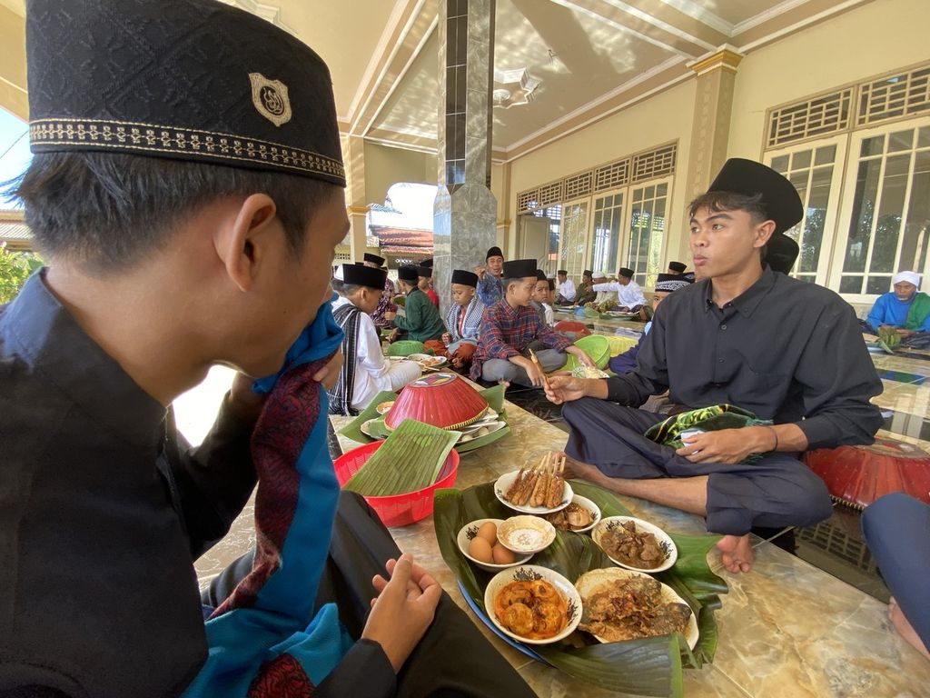 Warga duduk bersama di beranda Masjid Nurul Iman untuk <i>begibung</i> atau makan bersama usai Shalat Idul Fitri di Dusun Kwang Jukut, Desa Pringgarata, Lombok Tengah, Nusa Tenggara Barat, Senin (2/5/2022).