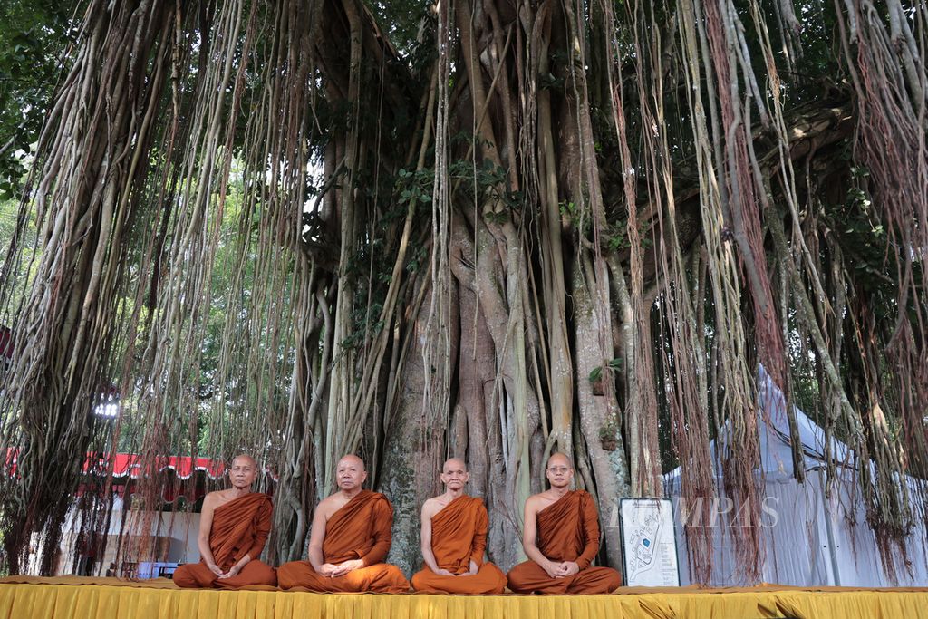 Biksu duduk bersila di bawah pohon bodhi sebelum melakukan tradisi pindapata di Candi Mendut, Magelang, Jawa Tengah, Rabu (22/5/2024). 