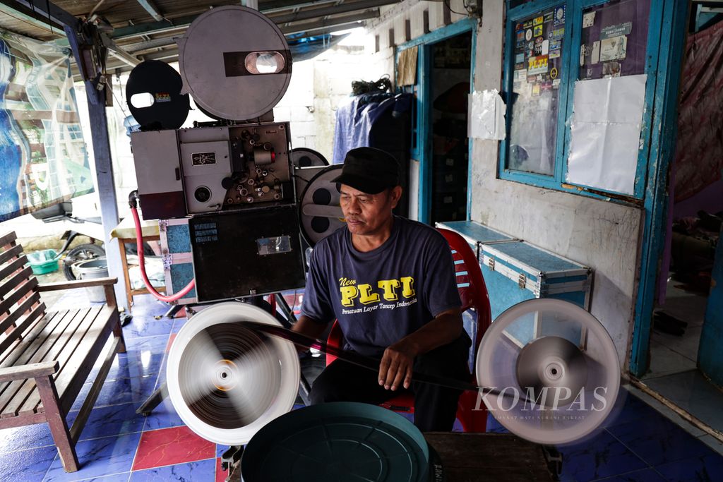 Nur Iyan (50) menggulung ulang film seluloid 35 milimeter koleksinya di kawasan Pamulang, Tangerang Selatan, Banten, Rabu (18/1/2023). Iyan merupakan pencinta film seluloid 35 mm yang biasa digunakan untuk layar tancap. 
