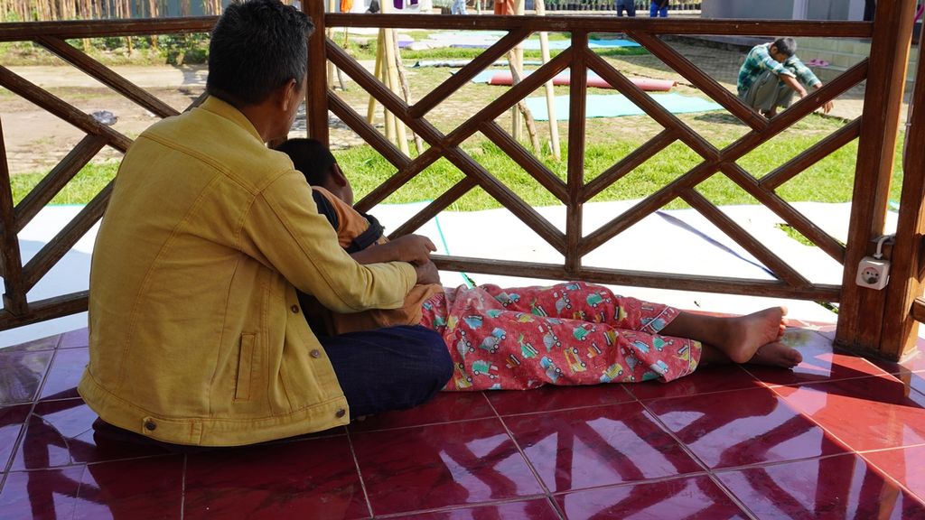 Yuliansyah Yanim, Penjaga di Istana KSJ Cianjur terlihat menenangkan salah satu penderita skizofrenia, M Abdul Fahri yang sebelumnya meronta-ronta pada Rabu (2/10/2019).