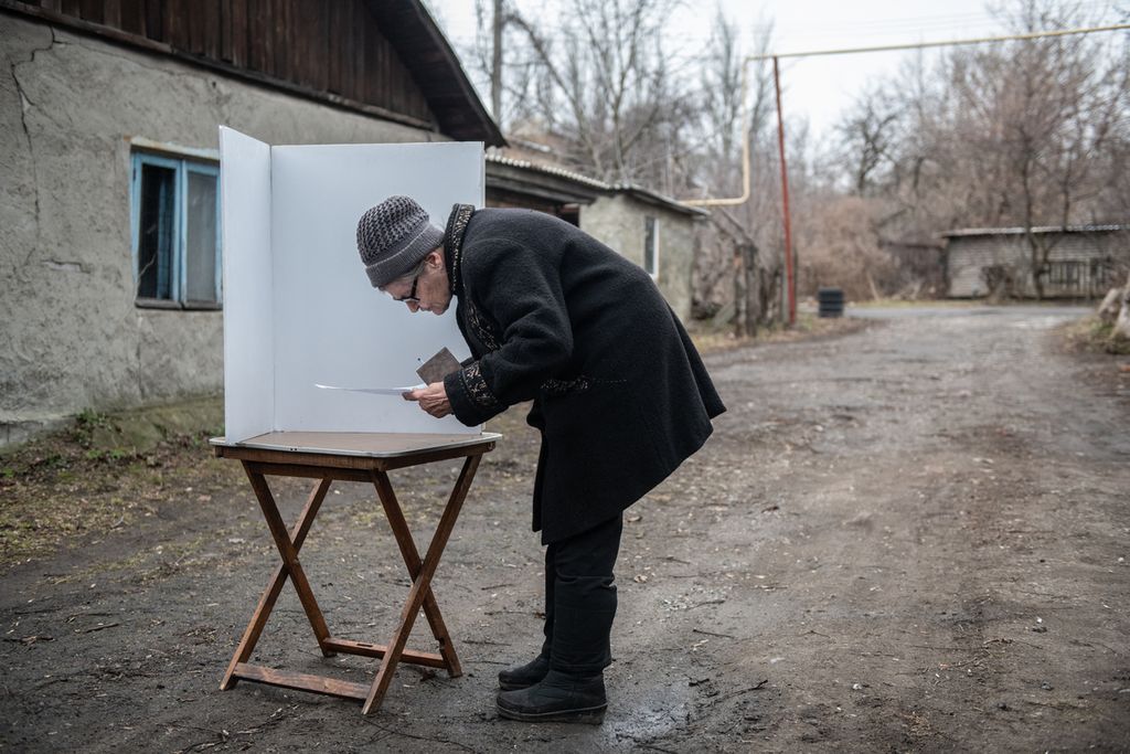 Warga memberikan suara di tempat pemungutan suara keliling saat pemungutan suara awal dalam pemilihan presiden Rusia di Donetsk, Ukraina, yang dikuasai Rusia, Kamis (14/3/2024). 