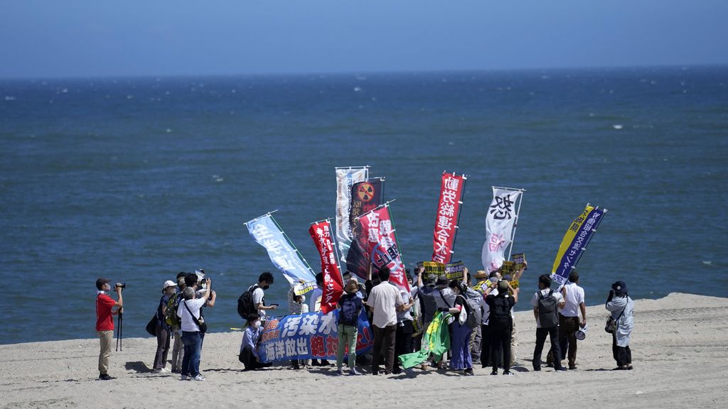 Warga berunjuk rasa di pantai Namie, Jepang, Kamis (24/8/2023). Pantai itu dekat PLTN Fukushima. Mereka menentang keputusan Jepang mulai membuang limbah PLTN Fuksuhima.