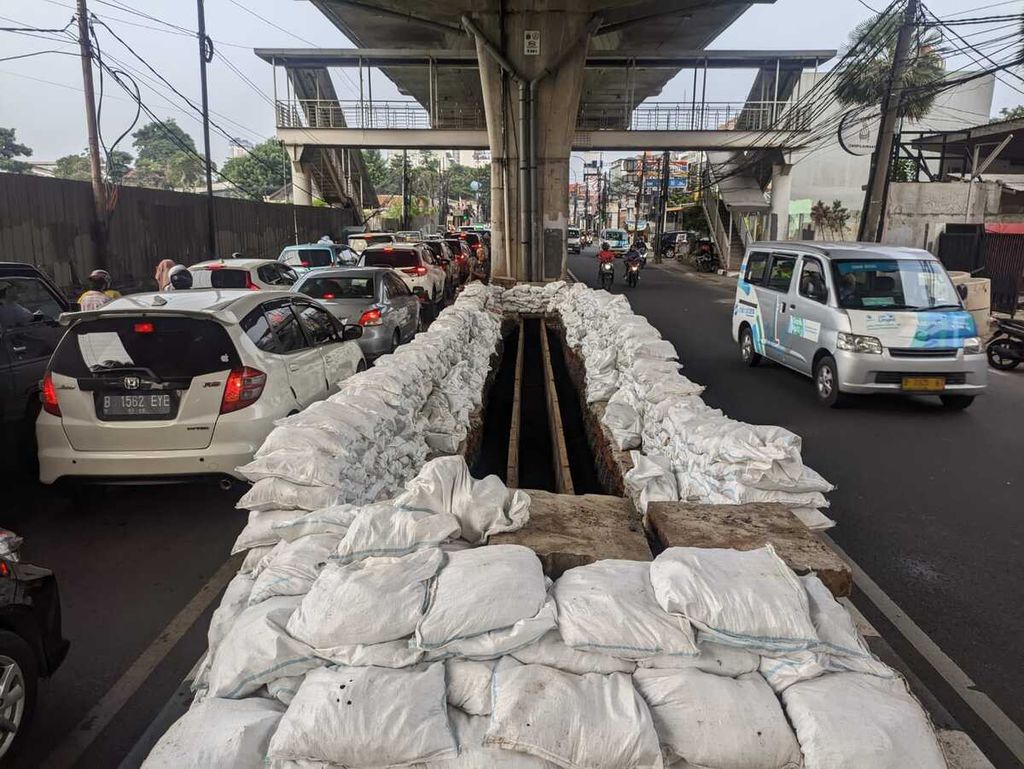 Tumpukan karung berisi tanah untuk membatasi proyek penggalian drainase vertikal dengan jalanan di kawasan Cipulir, Kebayoran Lama, Jakarta Selatan, Rabu (24/3/2023).