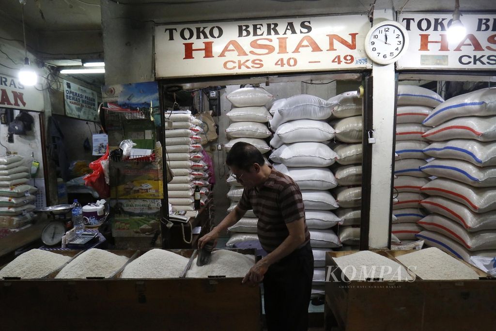Hasian, pedagang beras di Pasar Grogol, Jakarta Barat, sedang menunggu pembeli, Senin (25/9/2023). 