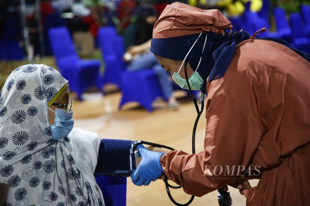 Petugas medis memeriksa tekanan darah seorang warga lansia sebelum menerima suntikan Covid-19 dosis pertama dalam vaksinasi massal bagi warga lansia di Balai Besar Pelatihan Kesehatan di Jakarta, Rabu (24/3/2021). 