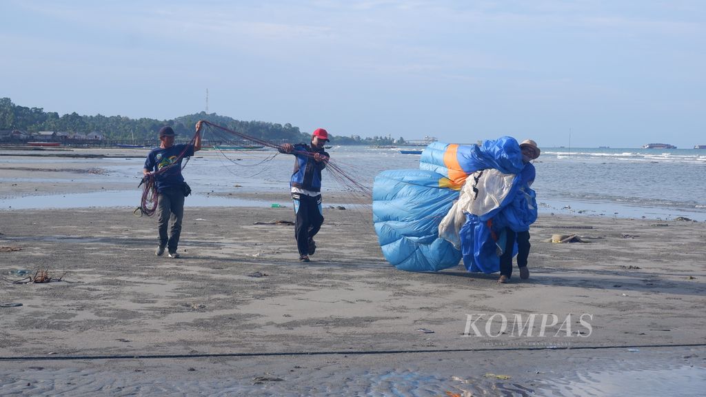 Petugas membawa parasut paralayang di pantai Desa Sarang Tiung, Kecamatan Pulau Laut Sigam, Kabupaten Kotabaru, Kalimantan Selatan, Kamis (7/7/2022). 