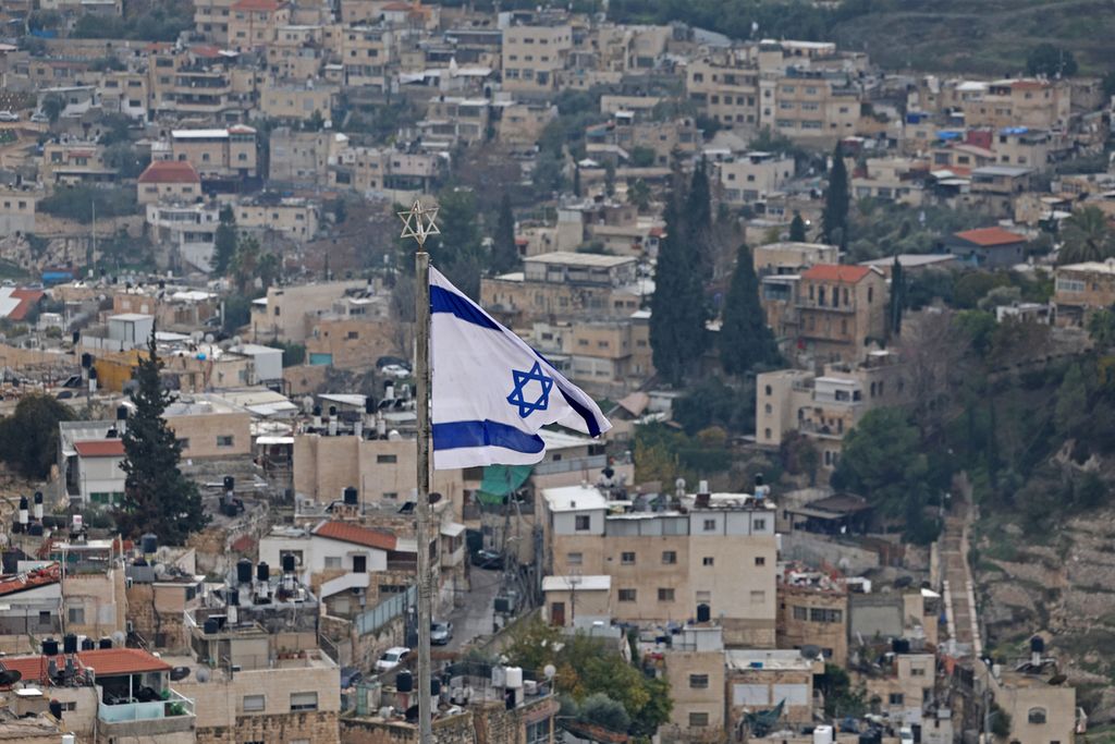 Pemandangan yang diambil dari Gunung Zaitun menunjukkan bendera Israel dengan latar belakang pemukiman di daerah pemukiman Arab, Silwan, Jerusalem. Senin (2/1/2023). 