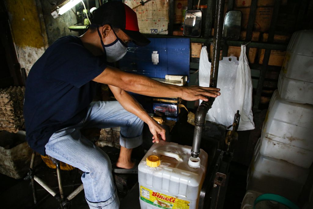 Pekerja mengisi minyak goreng curah pesanan pembeli di agen minyak goreng curah di kawasan Cipete Utara, Jakarta Selatan, Senin (29/11/2021). 