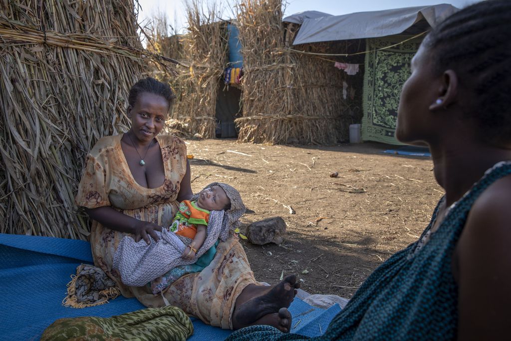 Pengungsi Etiopia, Blaines Alfao Eileen (kanan), yang sedang hamil 8 bulan menemani Lemlem Haylo Rada (25) yang sedang menyusui anaknya di kamp pengungsi Um Rakuba, Qadarif, Sudan, Senin (23/11/2020). Mereka ini melarikan diri akibat konflik militer di negara mereka. 