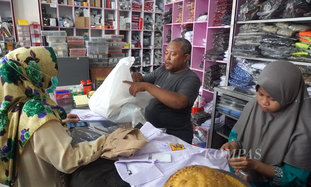 Pembeli mengecek seragam yang akan dibeli, Sabtu (11/7/2020) di toko seragam Kecamatan Tegal Timur, Kota Tegal, Jawa Tengah. Tahun ini, rata-rata harga seragam naik sebesar Rp 2.000 - Rp 3.000 per potong dari harga sebelumnya.